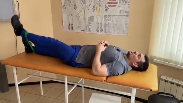 Démonstration de l'exercice avec une bande de résistance placée sur les tibias pour augmenter la charge de travail.