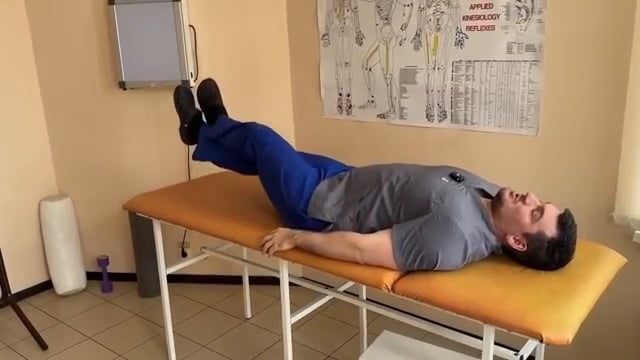 Démonstration de l'exercice avancé : une jambe posée sur l'autre pour ajouter du poids et de la résistance lors du levé de jambe.